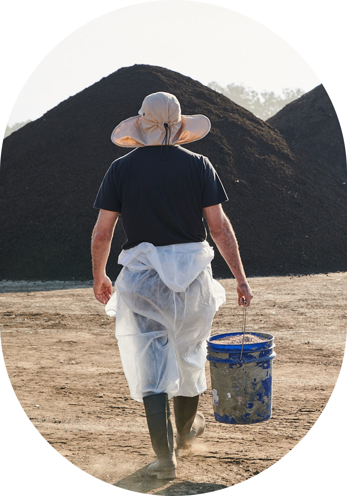 A worker carrying a bucket at a biological recycling facility